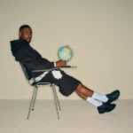 Skepta og puma sko, sidder på en stol