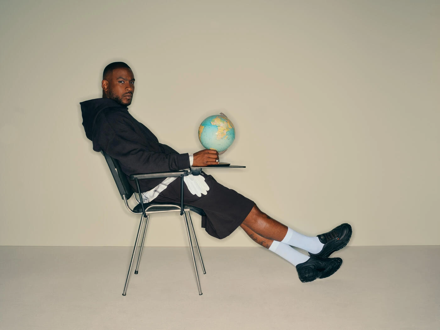 Skepta og puma sko, sidder på en stol