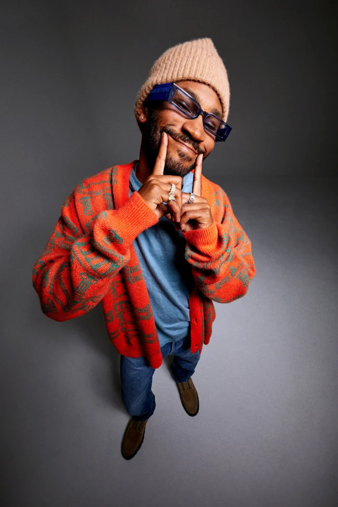 Kaytranada med orange cardigang og hue